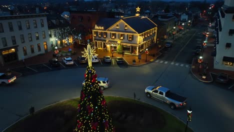 Driving-cars-in-roundabout-decorated-with-christmas-tree-at-night