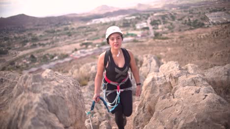 Woman-rock-climbing-aerial-view-of-sportsman-rapelling-mountain-in-La-Panocha,-el-Valle-Murcia,-Spain-woman-rapel-down-a-mountain-climbing-a-big-rock