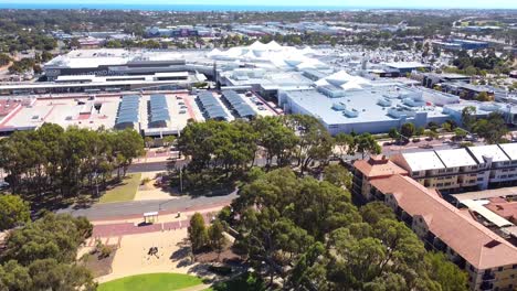 Vista-Aérea-Inclinada-Hacia-Arriba-Para-Revelar-El-Centro-Comercial-Junto-Al-Lago-Joondalup,-Perth