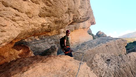 Sportsman-rock-climbing-aerial-view-of-sportsman-rapelling-mountain-in-La-Panocha,-el-Valle-Murcia,-Spain-woman-rapel-down-a-mountain-climbing-a-big-rock