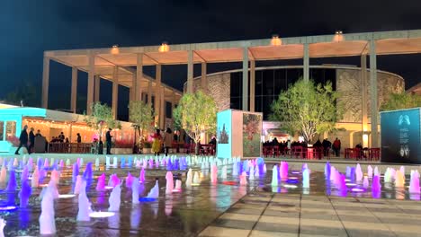 Colorful-lights-reflect-off-water-jet-fountain-in-front-of-The-Music-Center-in-Los-Angeles