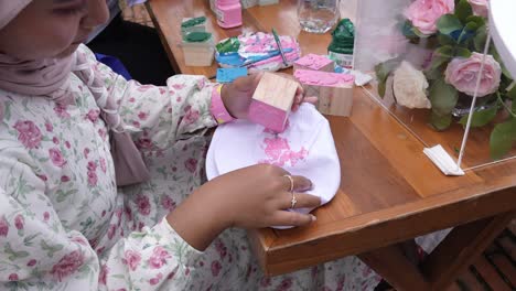 Girl-is-decorating-a-hat-using-a-stamp