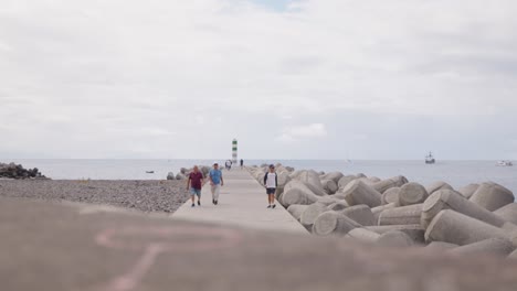 Menschen-Laufen-Auf-Einer-Mole-Mit-Konkreten-Wellenbrechern-In-Der-Nähe-Des-Atlantischen-Ozeans,-Madeira