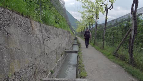 Un-Excursionista-Camina-Por-La-Ruta-De-Senderismo-Del-Canal-De-Riego-En-Algund---Lagundo,-Tirol-Del-Sur,-Italia