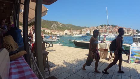 Beachgoers-walking-in-swimwear-on-Seafront-Promenade-in-Hvar-island,-Croatia