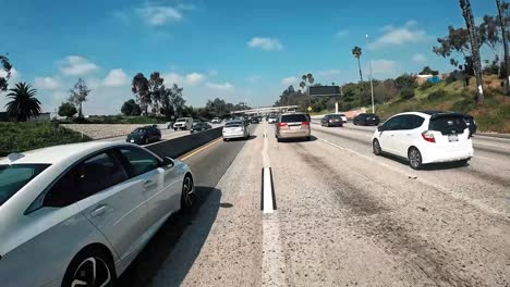 Motorcycle-rides-through-traffic-on-the-freeway-during-the-middle-of-the-day