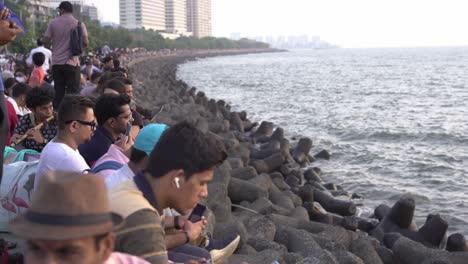 Touristen-Sitzen-Am-Marine-Drive-Mit-Blick-Auf-Das-Meer-Und-Beobachten-Den-Sonnenuntergang-In-Mumbai