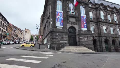 Leere-Am-Wochenende-Auf-Der-Straße-Von-Clermont-Ferrand-Mit-Ein-Paar-Radfahrern-Und-Motorrädern-Vor-Dem-Schwarzen-Vulkanischen-Regierungsgebäude---Präfektur-Puy-De-Dome