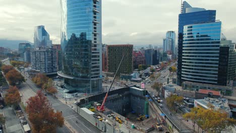 Santiago-de-Chile-downtown-cityscape-traffic,-aerial-drone-fly-high-skyscrapers-at-daylight-with-andean-cordillera-mountain-background,-autumnal-season