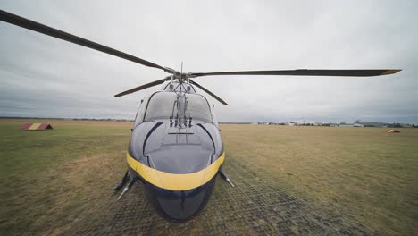 A-Bell-249-helicopter-sits-parked-on-the-grassy-field-at-Vaclav-Havel-Airport-in-Prague,-ready-for-its-next-flight