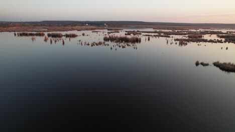 Una-Serena-Vista-Aérea-De-Un-Tranquilo-Paisaje-Del-Delta-Durante-La-Puesta-De-Sol-Con-Aguas-Tranquilas-Y-Tierra-Distante