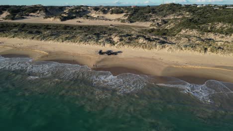 Tourist-Hält-Mit-4x4-Fahrzeugen-Am-Sandstrand-Bei-Sonnenuntergang