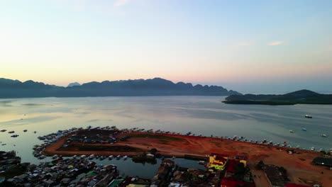 Luftaufnahme-Mit-Blick-Nach-Links-Auf-Den-Hafen-Von-Coron-Und-Die-Inselberge-Bei-Sonnenuntergang