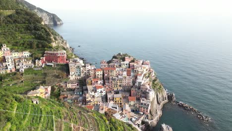 Manarola-Cinque-Terre-Italy-aerial-fly-over-farm-cliffs-to-show-buildings