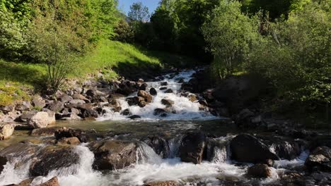 Mountain-stream-flowing-through-rocks-in-a-lush-green-forest