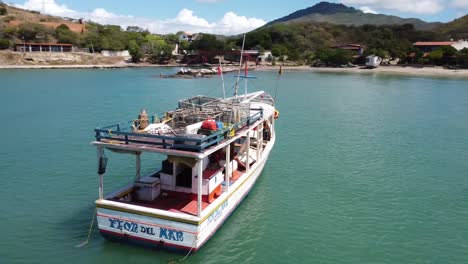 Fishermen-On-Fishing-Boat-Near-Beach-Playa-Zaragoza-and-Hills-In-Background,-Aerial-Orbital-View