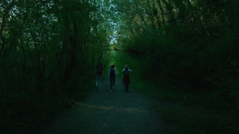 People-hiking-on-a-forest-path-in-Jarun,-Zagreb,-Croatia,-surrounded-by-dense,-lush-greenery