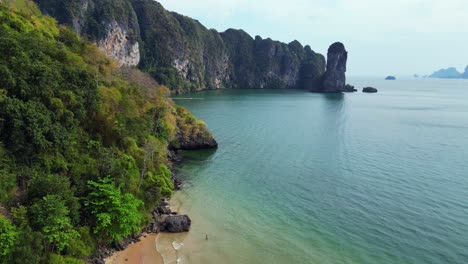 Impresionante-Vista-De-Una-Bahía-Aislada-Con-Agua-Turquesa,-Rodeada-De-Imponentes-Acantilados-Cubiertos-De-Exuberante-Vegetación-Verde.