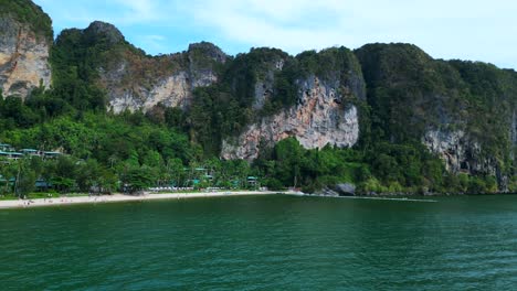 Impresionante-Vista-De-Una-Bahía-Aislada-Con-Agua-Turquesa,-Rodeada-De-Imponentes-Acantilados-Cubiertos-De-Exuberante-Vegetación-Verde.