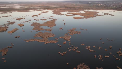 Comana-lake-with-scattered-islets-during-a-calm-evening,-aerial-view