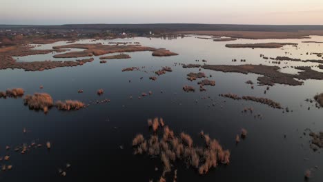 Vista-Aérea-Panorámica-Del-Delta-De-Neajlov-En-Comana-Durante-La-Puesta-De-Sol-Con-Aguas-Serenas-Y-Exuberante-Vegetación