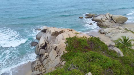 Rocky-coastline-with-foamy-ocean-waves-in-Colombia,-aerial-drone-view