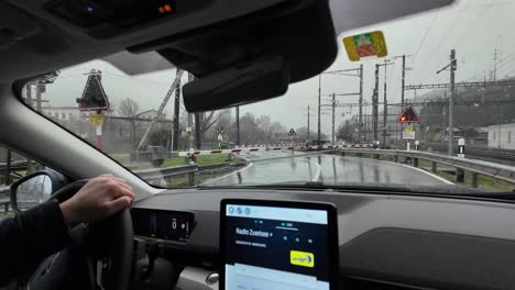 Waiting-for-train-to-pass-inside-the-car,-view-from-passenger,-light-rain