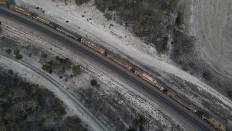 Toma-De-Arriba-Hacia-Abajo-De-Un-Tren-De-Carga-De-Combustible-En-El-área-De-Esperance,-Australia-Occidental