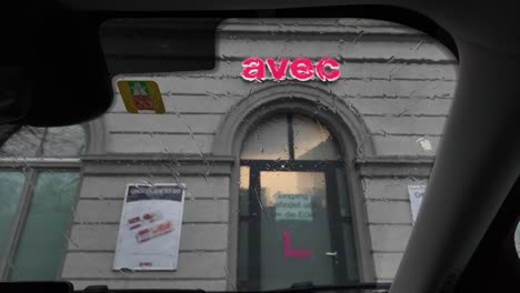 Vista-De-La-Tienda-De-Conveniencia-Avec-Desde-El-Interior-Del-Coche-Durante-La-Lluvia,-Zurich,-Suiza