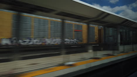 Weite-Aufnahme-Mit-Blick-Auf-Den-Passagier-Aus-Einem-Fahrenden-Zug,-Mit-Blick-Auf-Den-Vorbeifahrenden-Bahnsteig-Und-Den-Auf-Einem-Anderen-Gleis-Fahrenden-Zug