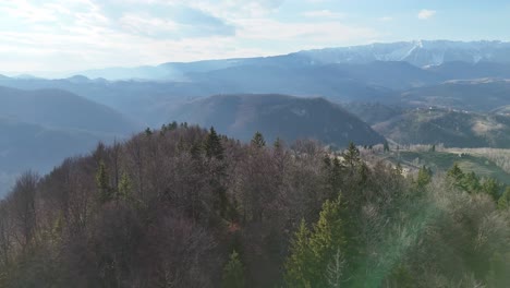 Forested-hills-and-mountains-on-a-clear-day,-aerial-view