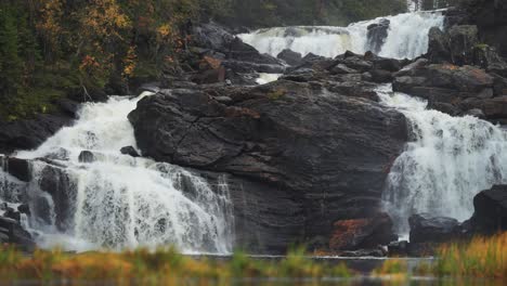 Una-Cascada-Fluye-Con-Gracia-Sobre-Los-Oscuros-Acantilados-Del-Bosque-Noruego,-Creando-Un-Oasis-De-Tranquilidad.