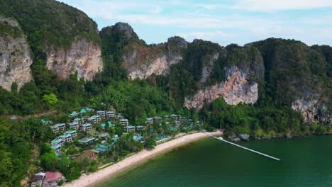 Breathtaking-view-of-a-secluded-bay-with-turquoise-water,-surrounded-by-towering-cliffs-covered-in-lush-green-vegetation