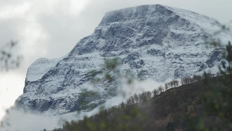 Frischer-Schnee-Auf-Den-Dunklen-Berggipfeln-über-Dem-Waldbedeckten-Tal