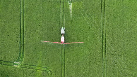 Vista-Aérea-De-Un-Campo-De-Cultivo-Con-Un-Tractor-Rociando-Pesticidas