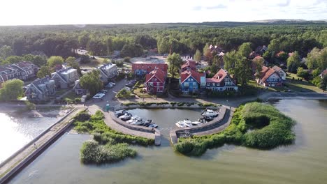 Aerial-view-of-Pervalka,-a-village-on-the-Curonian-Spit-in-Lithuania,-showcasing-colorful-houses-and-serene-waters