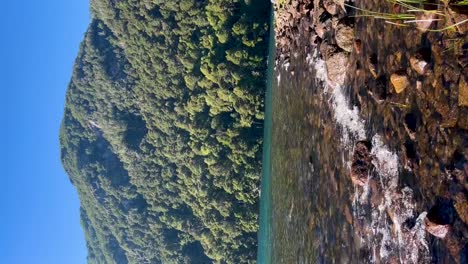 Clear-water-and-lush-green-mountains-in-Argentinian-Patagonia-during-a-sunny-day