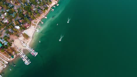 Aerial-Drone-Flyover-Waterfront-Cabins,-Water,-Boats,-Beach,-And-Docks-Along-The-Shoreline-At-Bass-Lake,-California