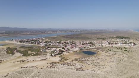 Armona-island-with-sandy-beaches,-lagoons,-and-small-coastal-village-in-Olhao-Portugal,-aerial-view