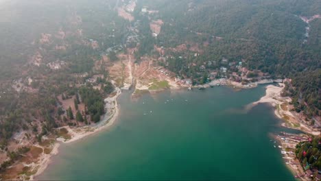 Luftaufnahme-Einer-Drohne-über-Dem-Dunstigen-Ufer,-Den-Wäldern-Und-Hütten-Am-Bass-Lake,-Kalifornien