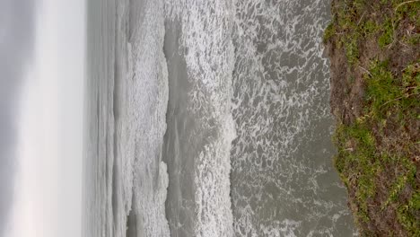 Waves-crashing-on-a-rocky-shore-along-the-Argentinian-coast,-vertical-shot