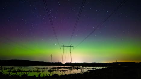 Silueta-De-Líneas-Eléctricas-Con-Aurora-Boreal-Arriba,-Vista-De-Lapso-De-Tiempo