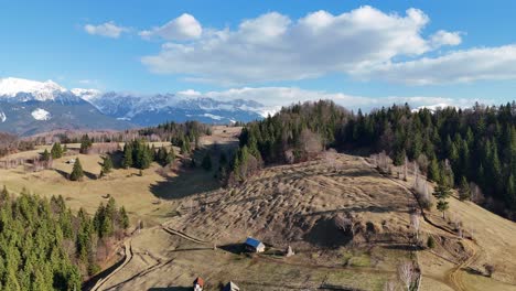 A-peaceful-mountain-village-with-scattered-houses-and-lush-green-forests,-aerial-view