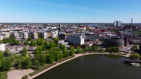 Panoramic-aerial-dolly-over-waterfront-with-lush-green-trees-in-Helsinki-Finland