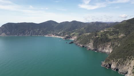 Monterosso-Cinque-Terre-Italy-aerial-high-and-wide-shows-village-in-beautiful-setting-mountains-and-ocean