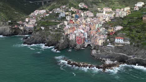 Riomaggiore-Cinque-Terre-Italy-aerial-static-view-as-waves-roll-in