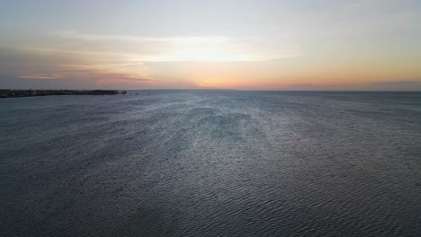 Aerial-of-palm-tree's-revealing-coast-and-gorgeous-vibrant-sunset-over-isla-de-margarita