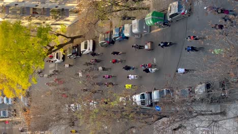 A-busy-city-street-full-with-bikers-and-cars-in-autumn,-aerial-view