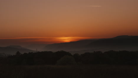 Timelapse-of-Sunrise-On-Horizon-Over-Welsh-Valley-Landscape-with-Mountain-Background-with-Low-Lying-Fog-and-Trees