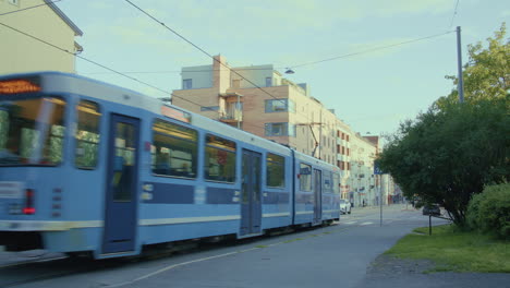 Tram-passing-by-with-pedestrians-walking-in-Oslo-city